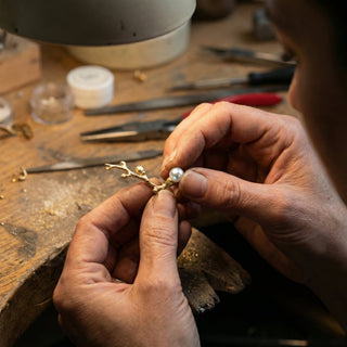 Efemera artisan handcrafting gold and pearl jewelry at workbench - polished pearls