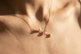 Efemera Symphonia necklace super macro - gold pearl branch pendant on bare collarbone morning sun